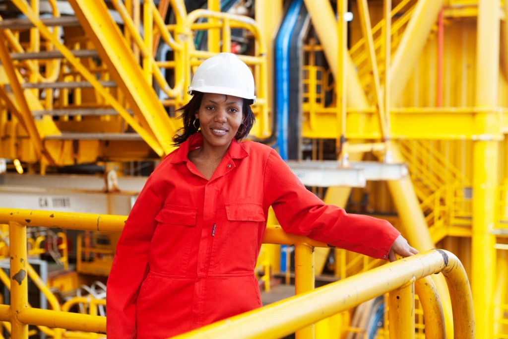 Mossel Bay, Southern Cape, South Africa, December 13,  2007.  Black woman roughneck with red overall and white hardhat on the rig, FA Platform,  off the cost of Mossel Bay.