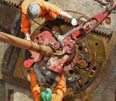 An elevated view of drill operators working on the drilling floor on an oil rig.